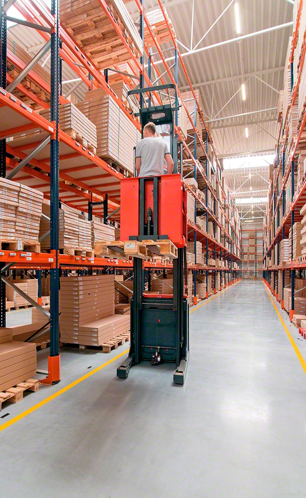 Los operarios se sirven de máquinas preparadoras de pedidos de altas cotas para hacer picking en los niveles superiores