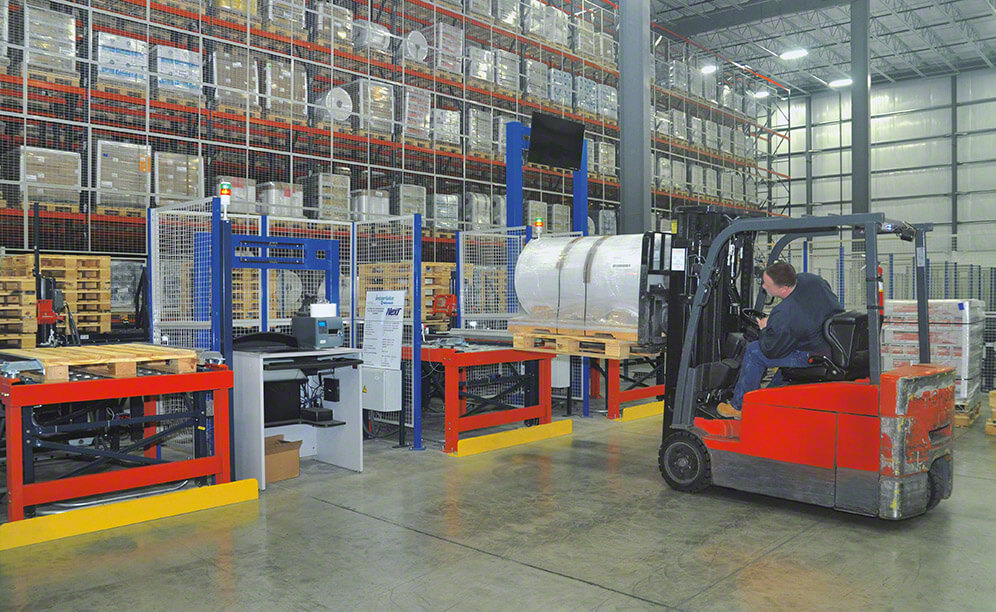 Los operarios colocan la carga encima de la tarima esclava utilizando carretillas contrapesadas