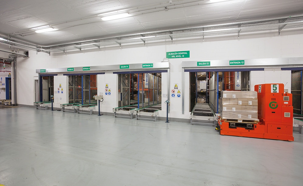 Los montacargas elevadores de guiado automático (AGV) recogen las tarimas y las depositan en los transportadores de entrada al almacén